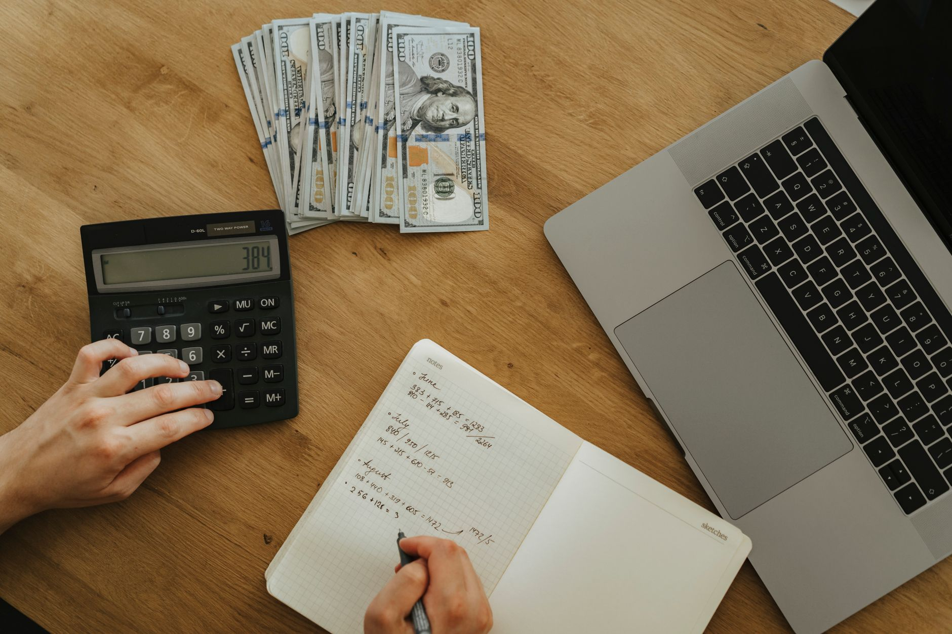 Open notebook on a sunlit kitchen counter showing a hand-drawn weight-loss trajectory curve with a 12-month timeline beside a calculator and a digital kitchen scale