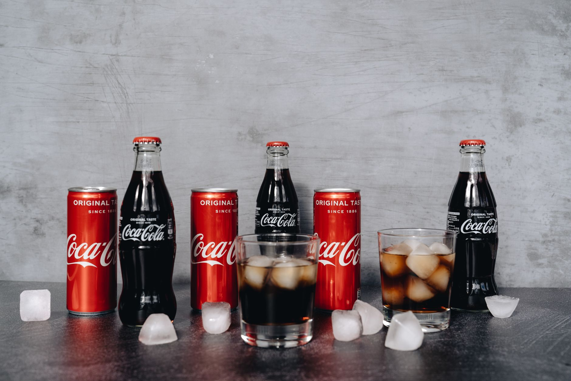 Cans, bottles, and glasses of cola soft drinks, the single largest source of added sugar in the US diet