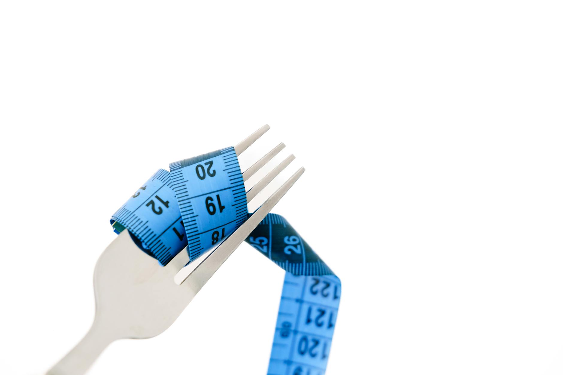 Balanced meal on a kitchen scale next to a notebook with calorie calculations showing energy balance concepts