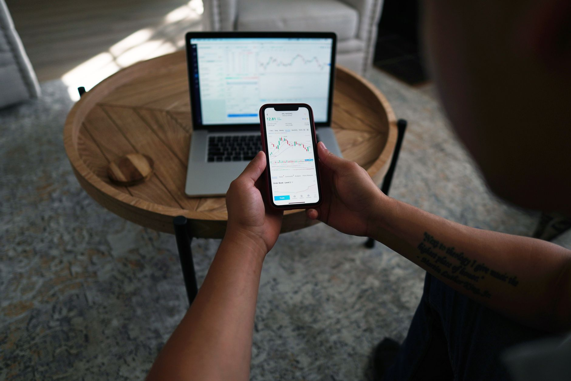 A person reviewing a weekly weight-trend graph and a calorie app on a phone at a kitchen table, weighing whether to eat back exercise calories