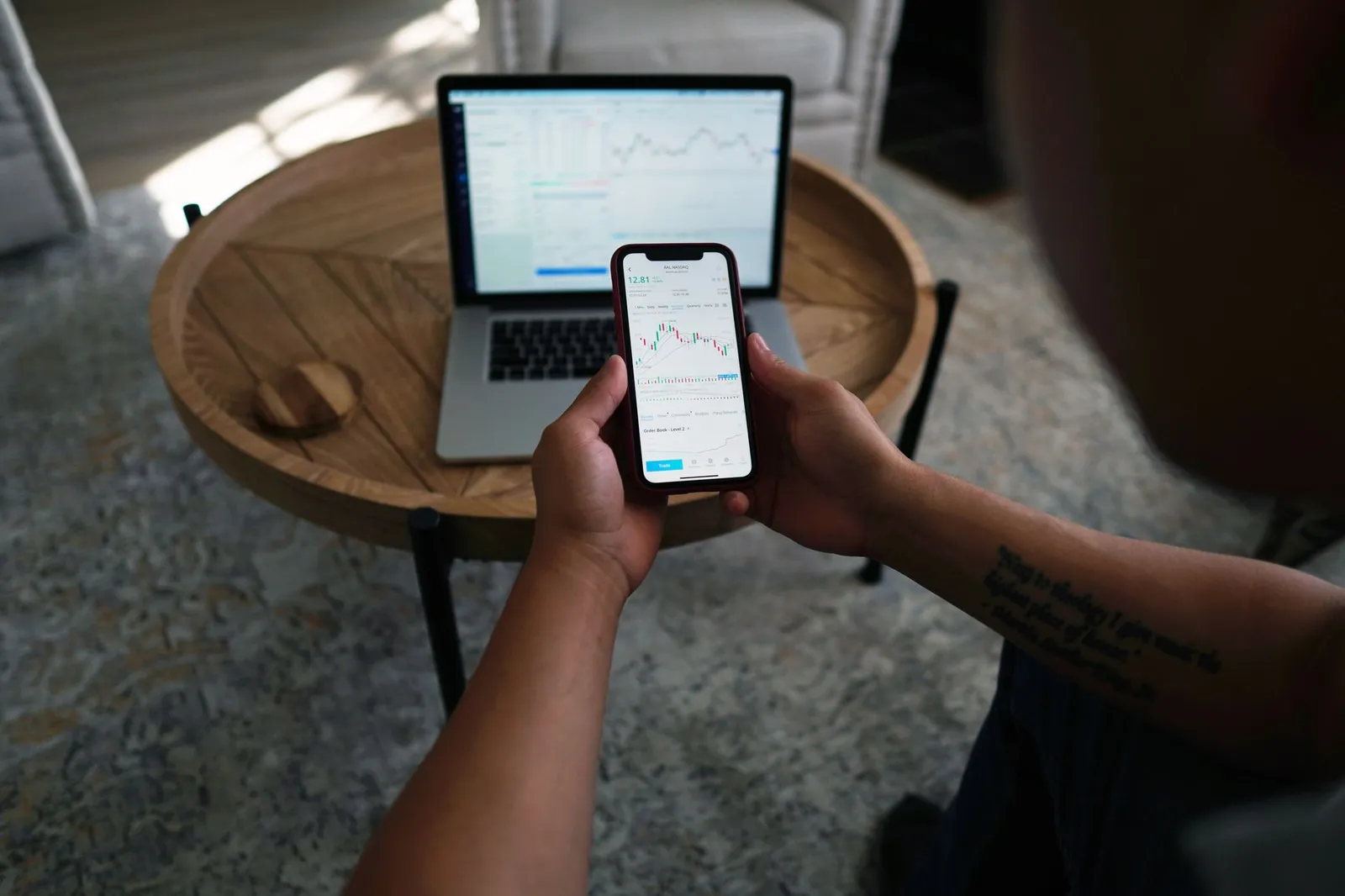 A person reviewing a weekly weight-trend graph and a calorie app on a phone at a kitchen table, weighing whether to eat back exercise calories