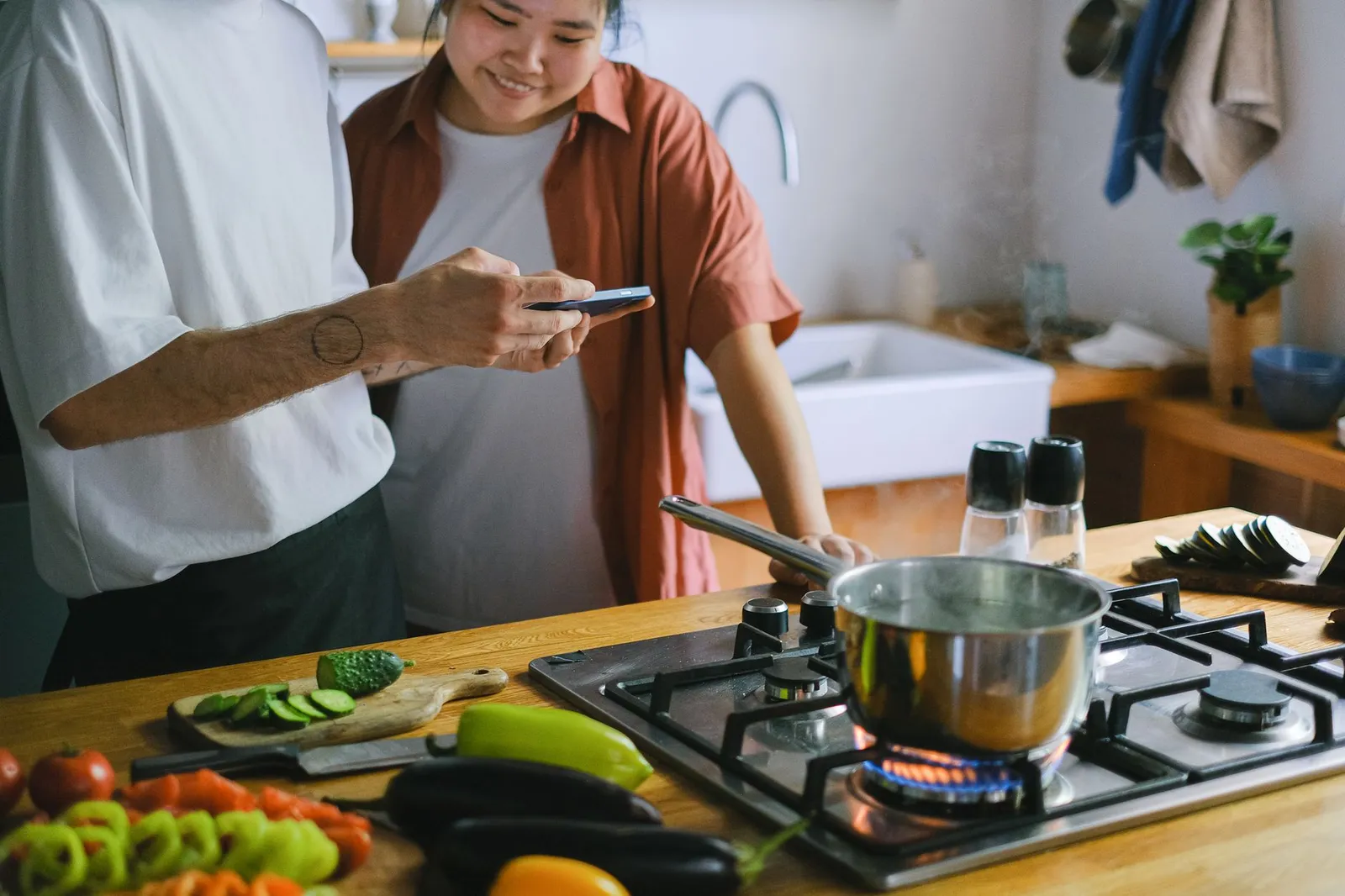 HelloFresh meal kit ingredients — chicken breast, fresh vegetables, herbs, and the recipe card — spread across a sunlit Australian kitchen counter beside a kitchen scale and a smartphone showing a calorie tracking app