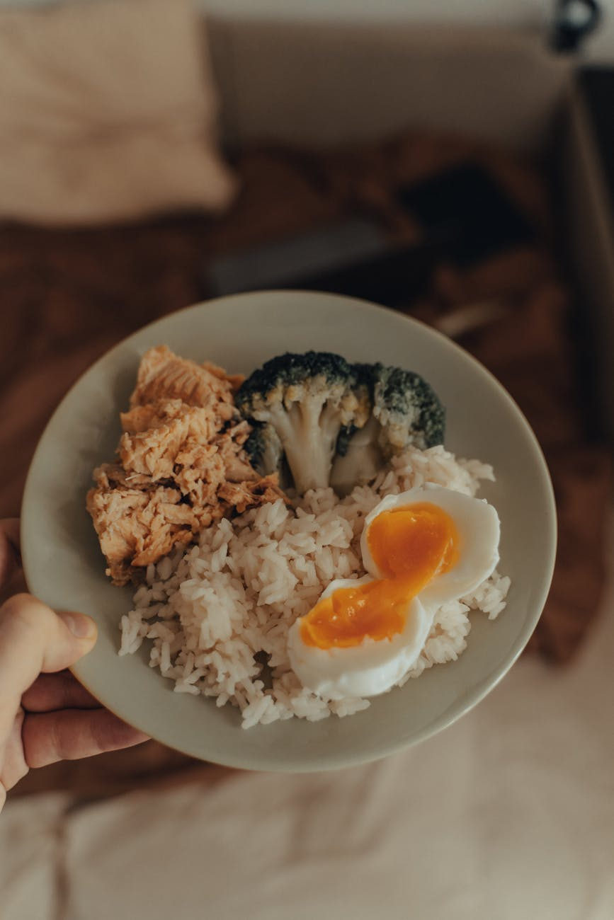 Smartphone showing a hormone tracking dashboard alongside a balanced meal with eggs, salmon, and leafy greens on a kitchen counter