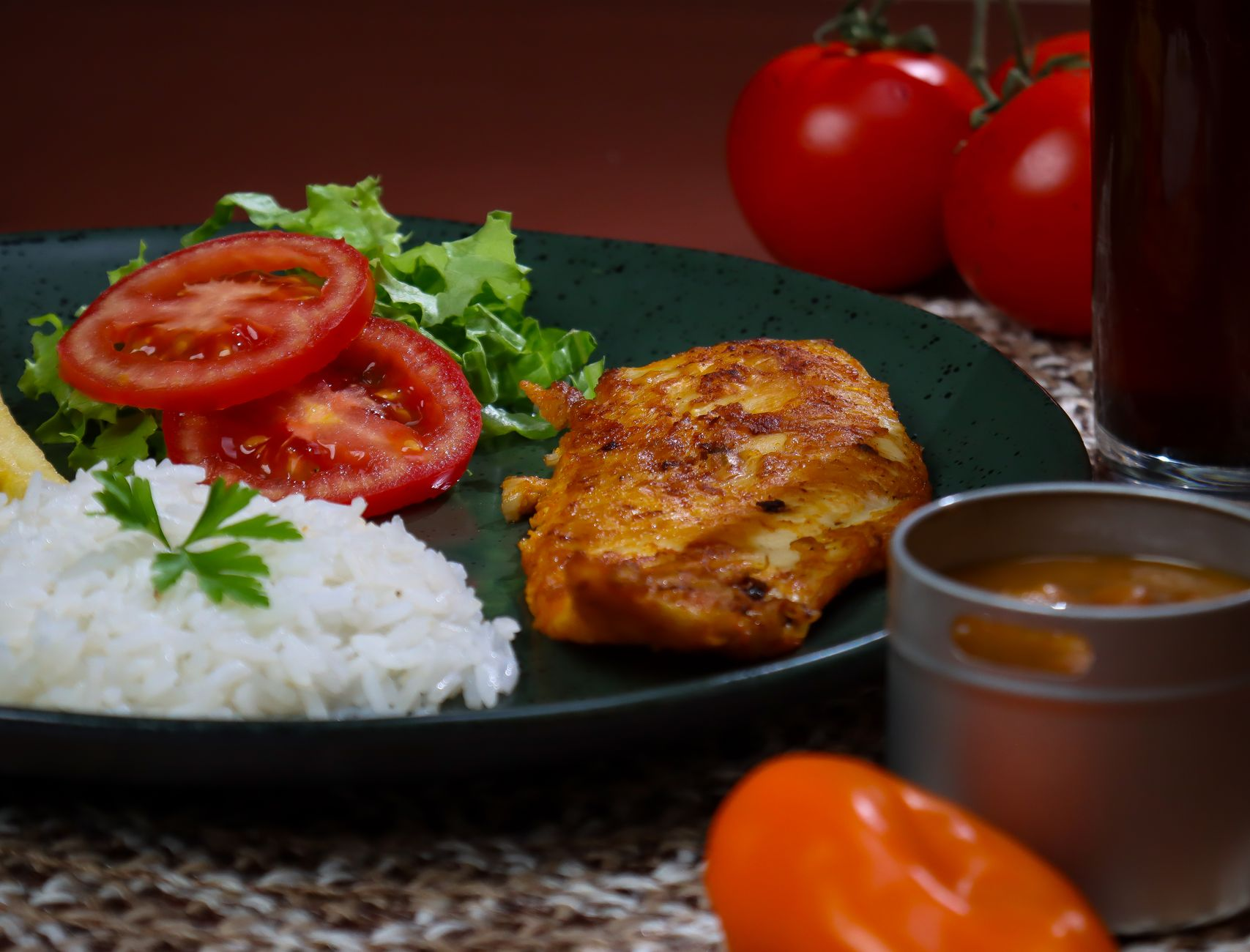 A printed macro-target table beside a digital kitchen scale weighing chicken breast, a smartphone showing a macro-tracking app, and a portioned meal of brown rice, greens, and grilled chicken on a sunlit kitchen counter