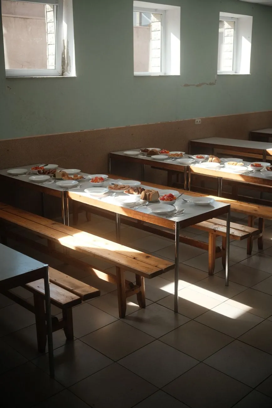 Plates of food set on dining tables beside wooden benches