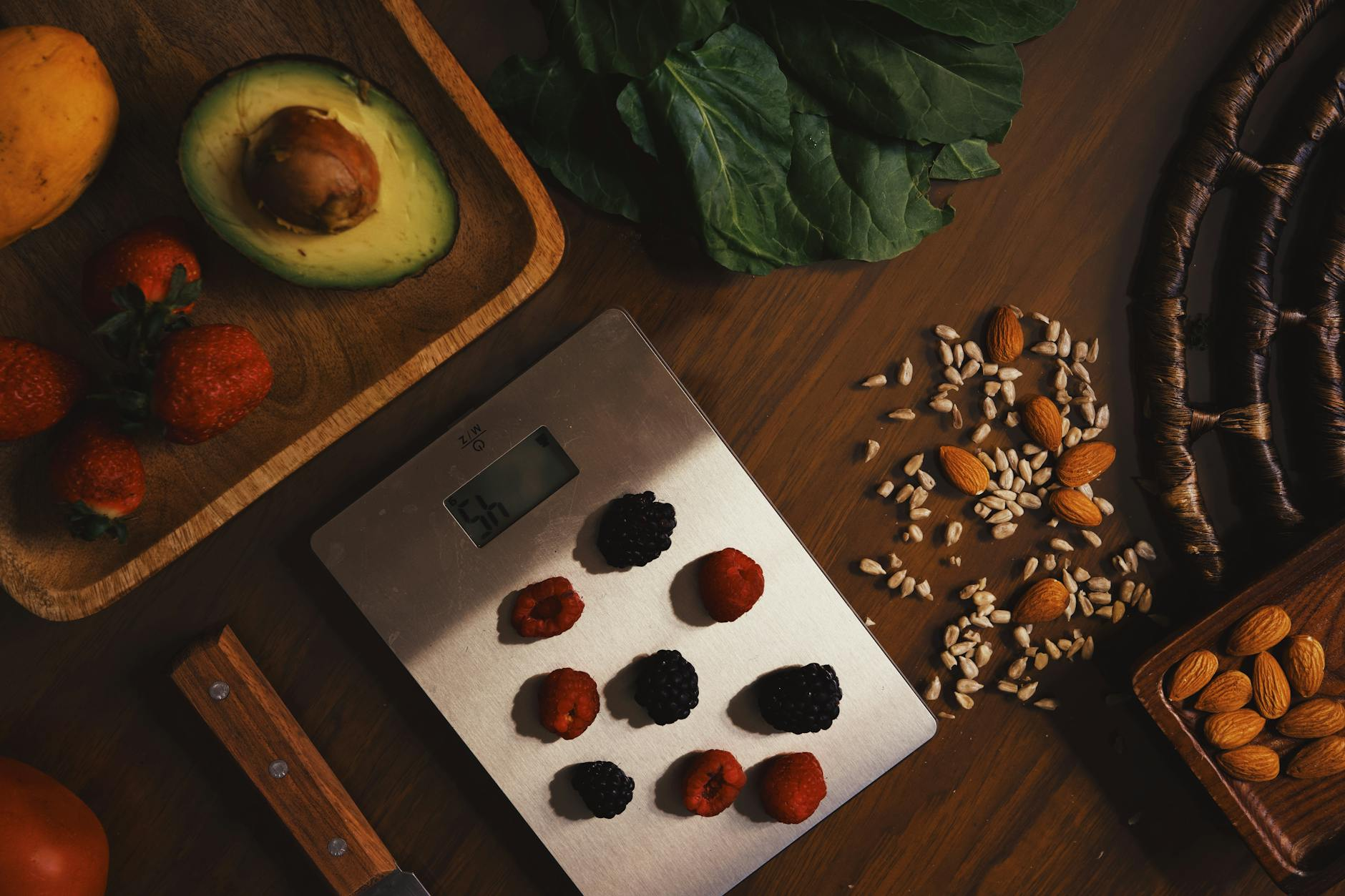 Colorful spread of micronutrient-rich whole foods including leafy greens, berries, nuts, seeds, and citrus fruit on a kitchen counter