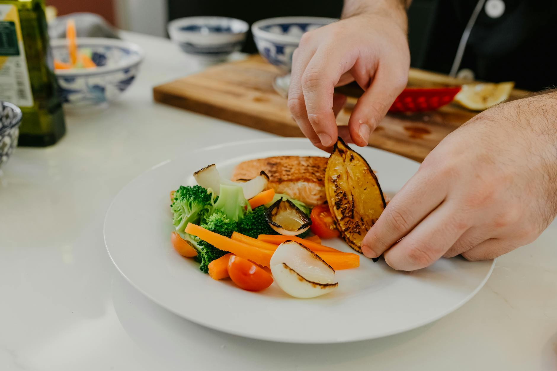Post-workout high-protein meal with grilled salmon, sweet potato, broccoli, and a smartphone tracking app on a kitchen counter