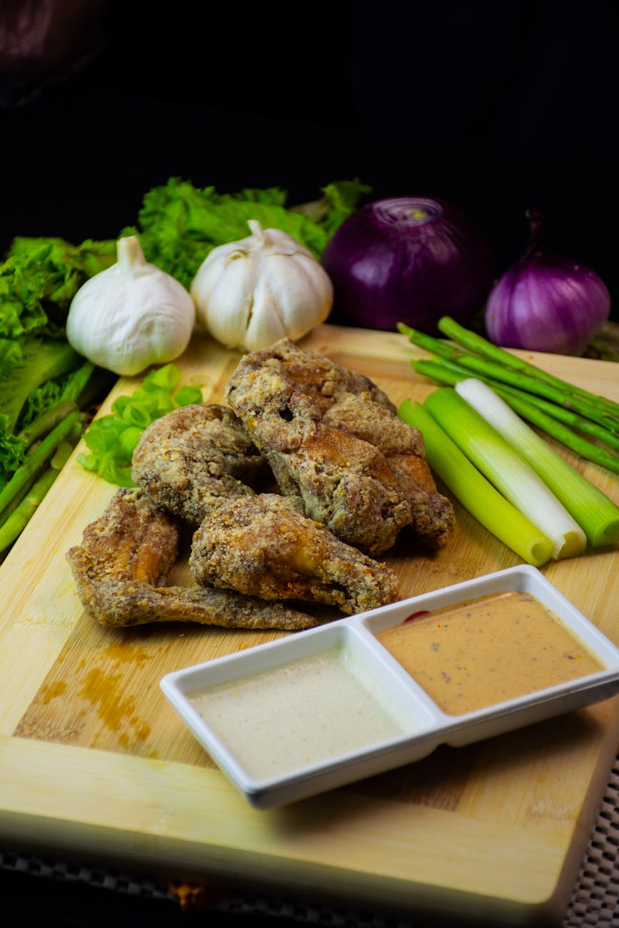 Prebiotic-rich foods including garlic, onions, leeks, bananas, and asparagus arranged on a rustic wooden cutting board