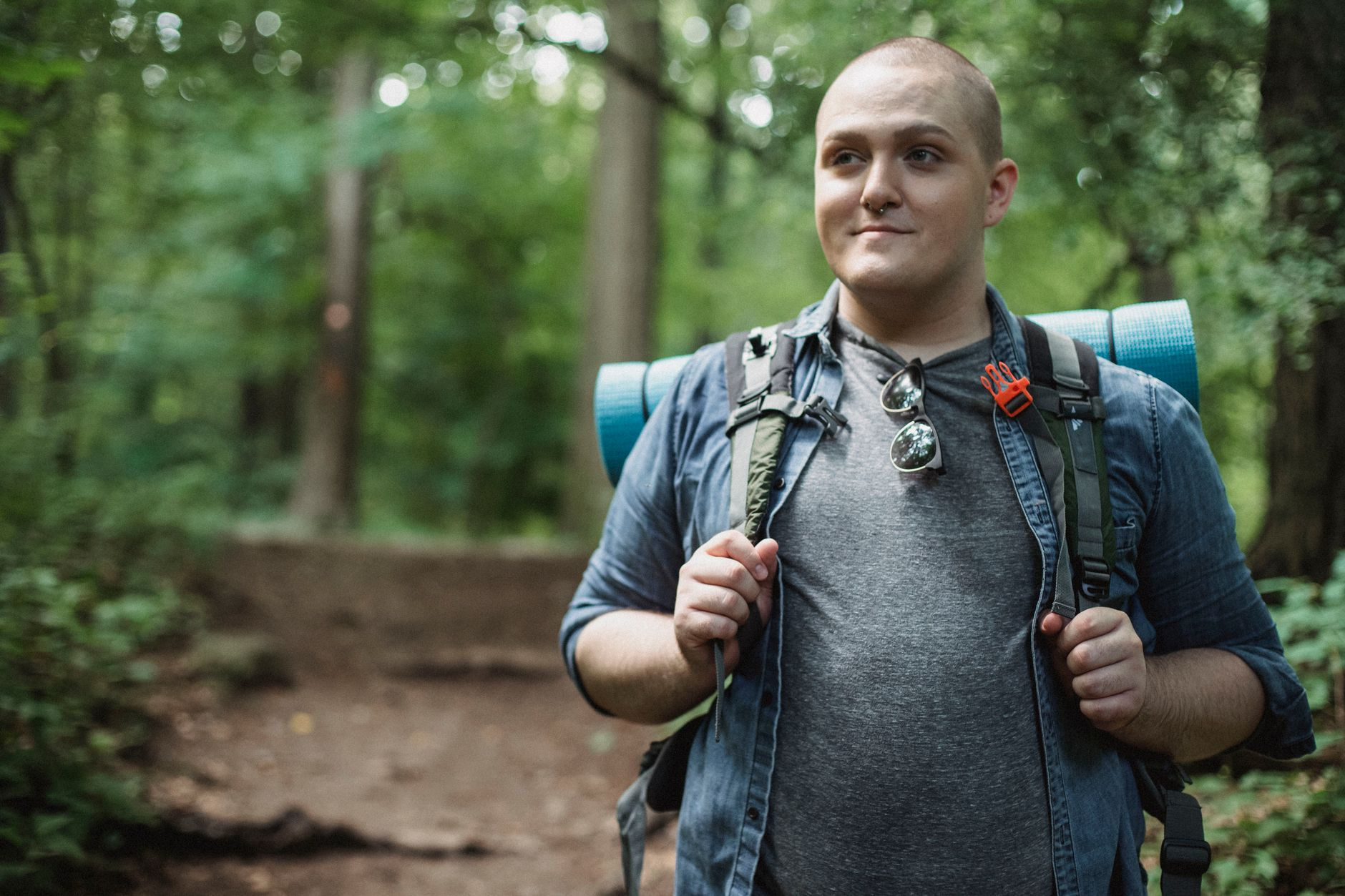 A hiker wearing a loaded rucksack walking up a sunlit trail beside a smartwatch showing a calorie-burn number and a smartphone with a calorie tracking app, illustrating how load, pace, grade, and terrain set rucking calorie burn