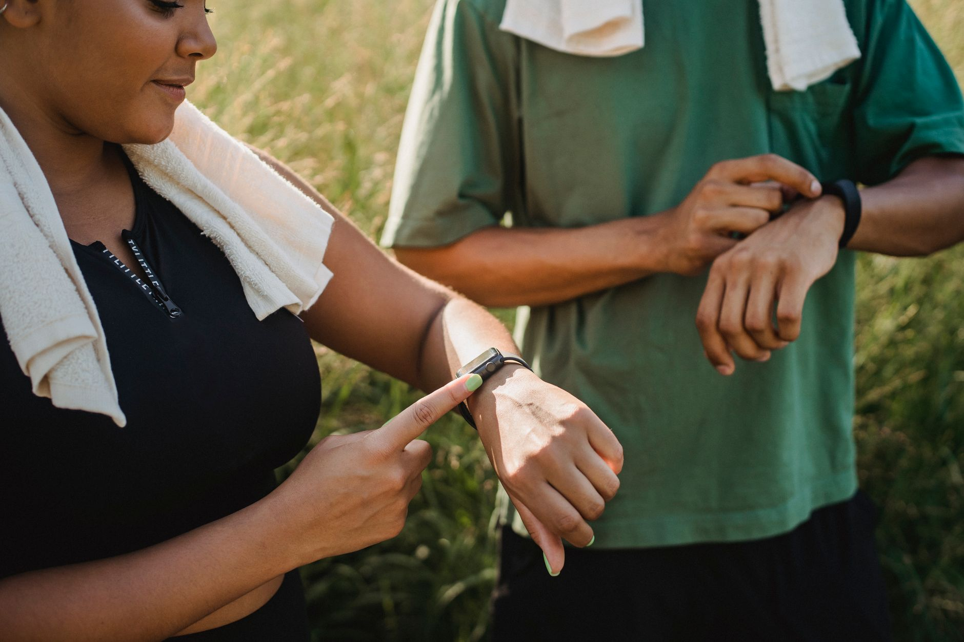 A runner glancing at a smartwatch mid-run beside a phone showing a running-app calorie graph, illustrating how wearables estimate rather than measure energy expenditure
