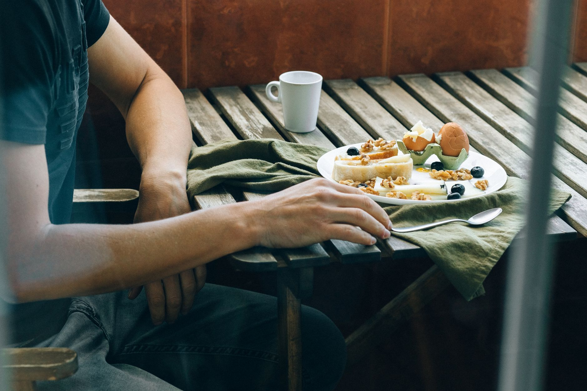 Boiled potatoes, eggs, grilled fish, and fresh fruit beside a printed satiety index ranking on a sunlit wooden table, illustrating the whole foods that top the fullness-per-calorie table