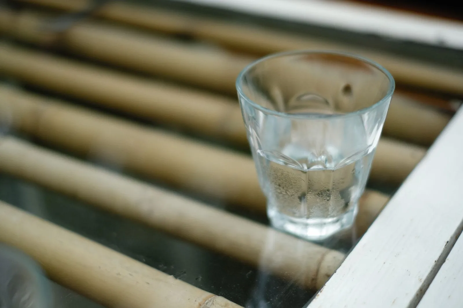 A glass of water on a glass-topped table