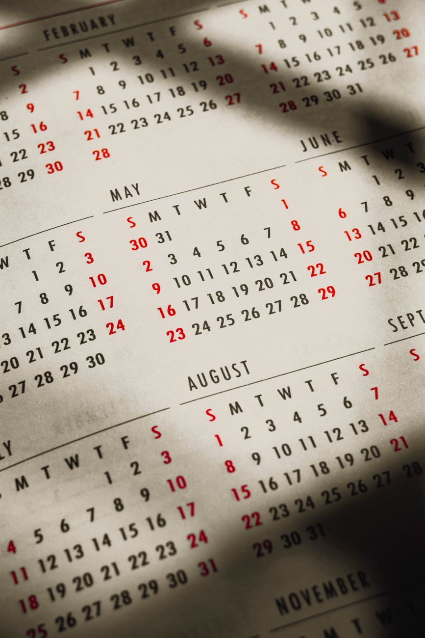 A calendar page with a week of highlighted sleep hours, a bathroom scale, a measuring tape, and a printed body-composition report on a sunlit bathroom shelf