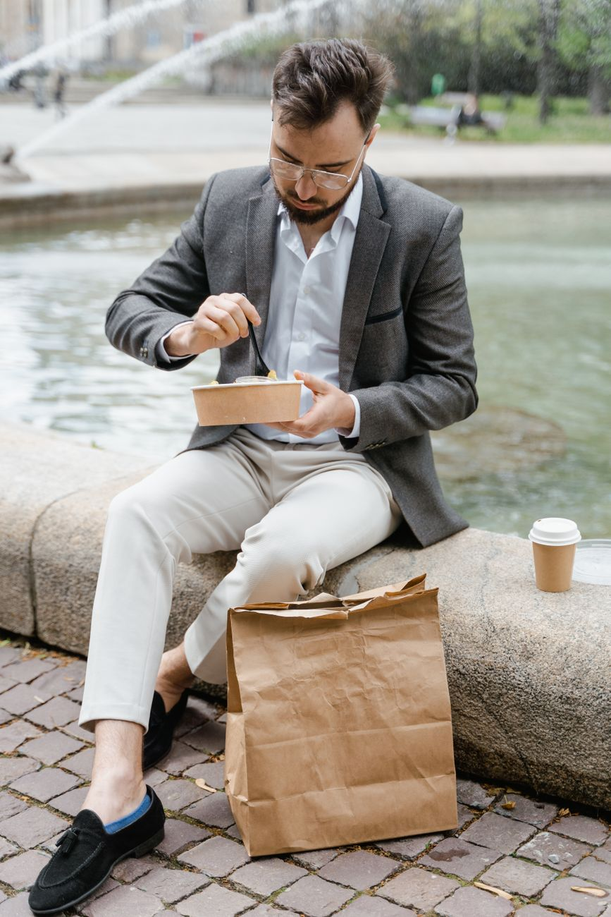 An office worker taking a walking break along a sunny city footpath at lunchtime, illustrating that a short walk burns more calories than hours of standing
