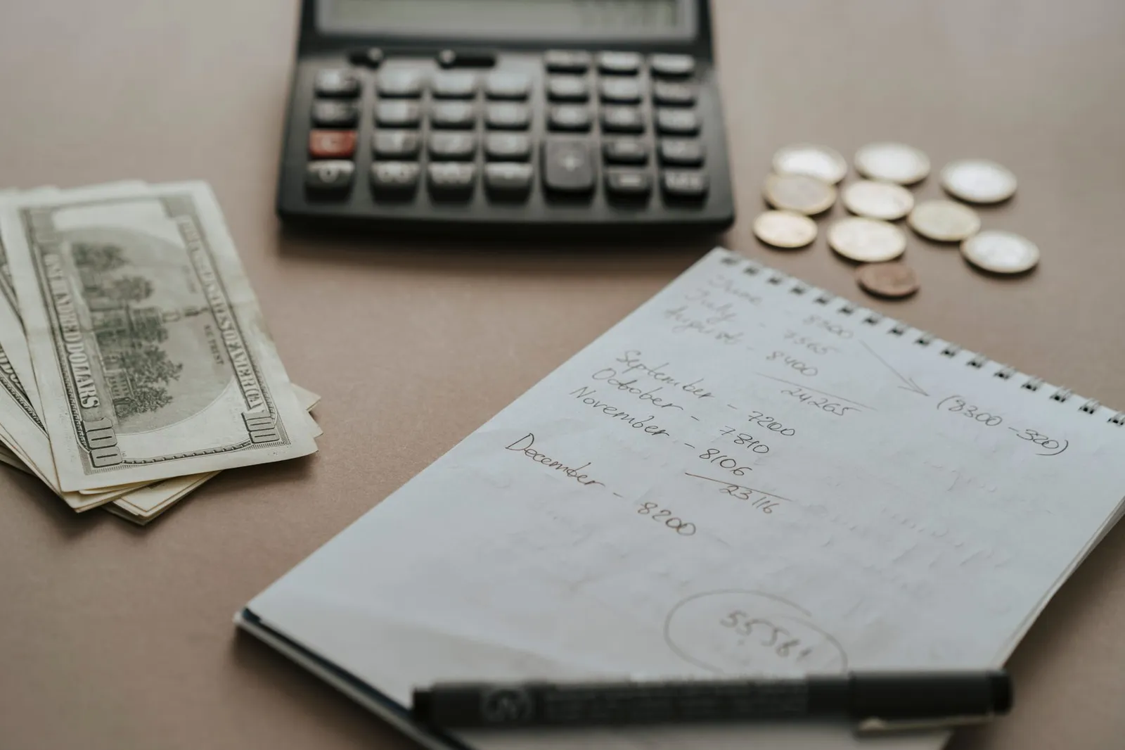 Open notebook with handwritten TDEE multiplier table beside a kitchen scale and a balanced meal on a sunlit kitchen counter